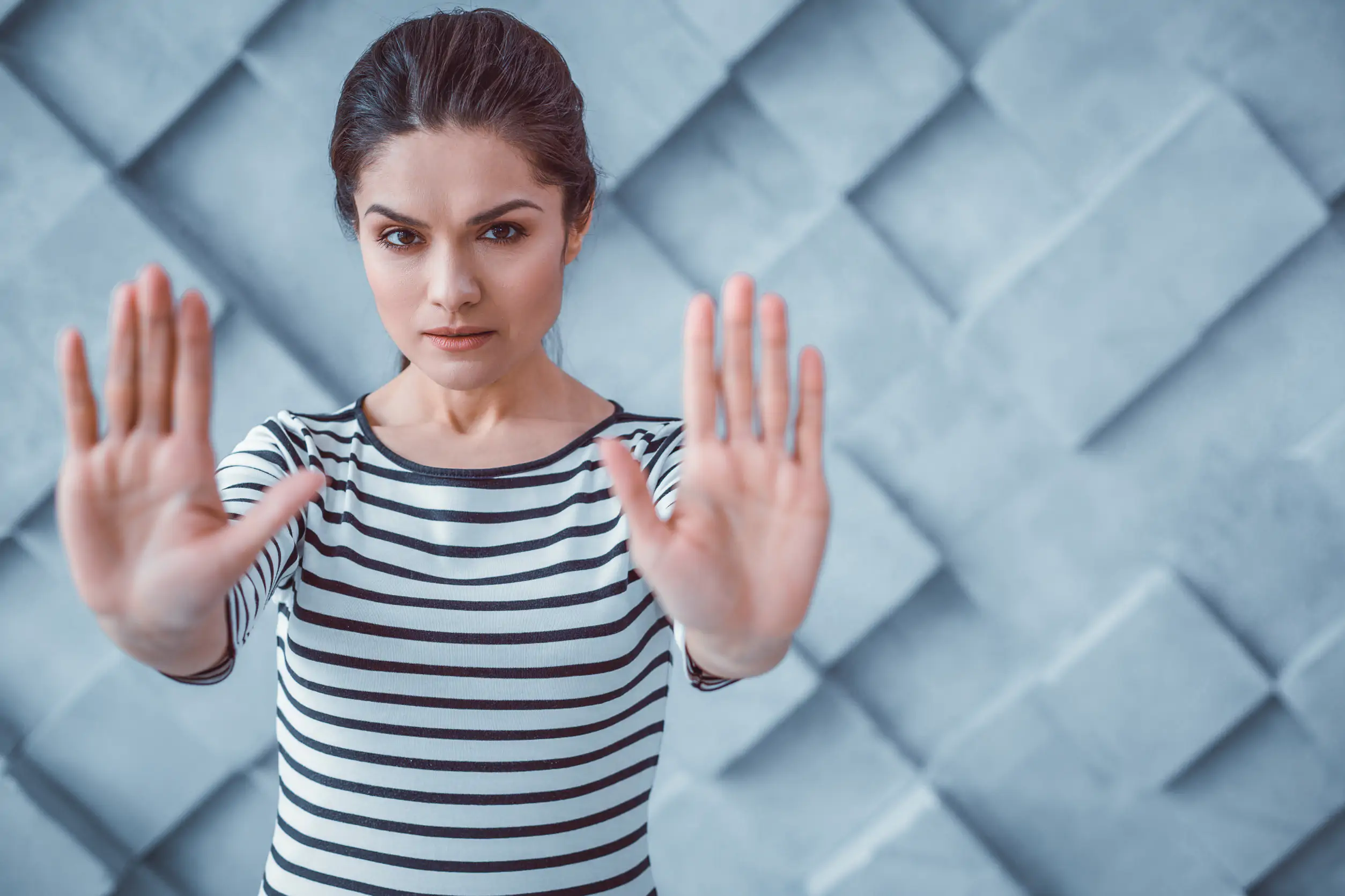 Act of protest. Dissent dark-haired woman pushing her hands forward showing disapprobation of actions and opinions