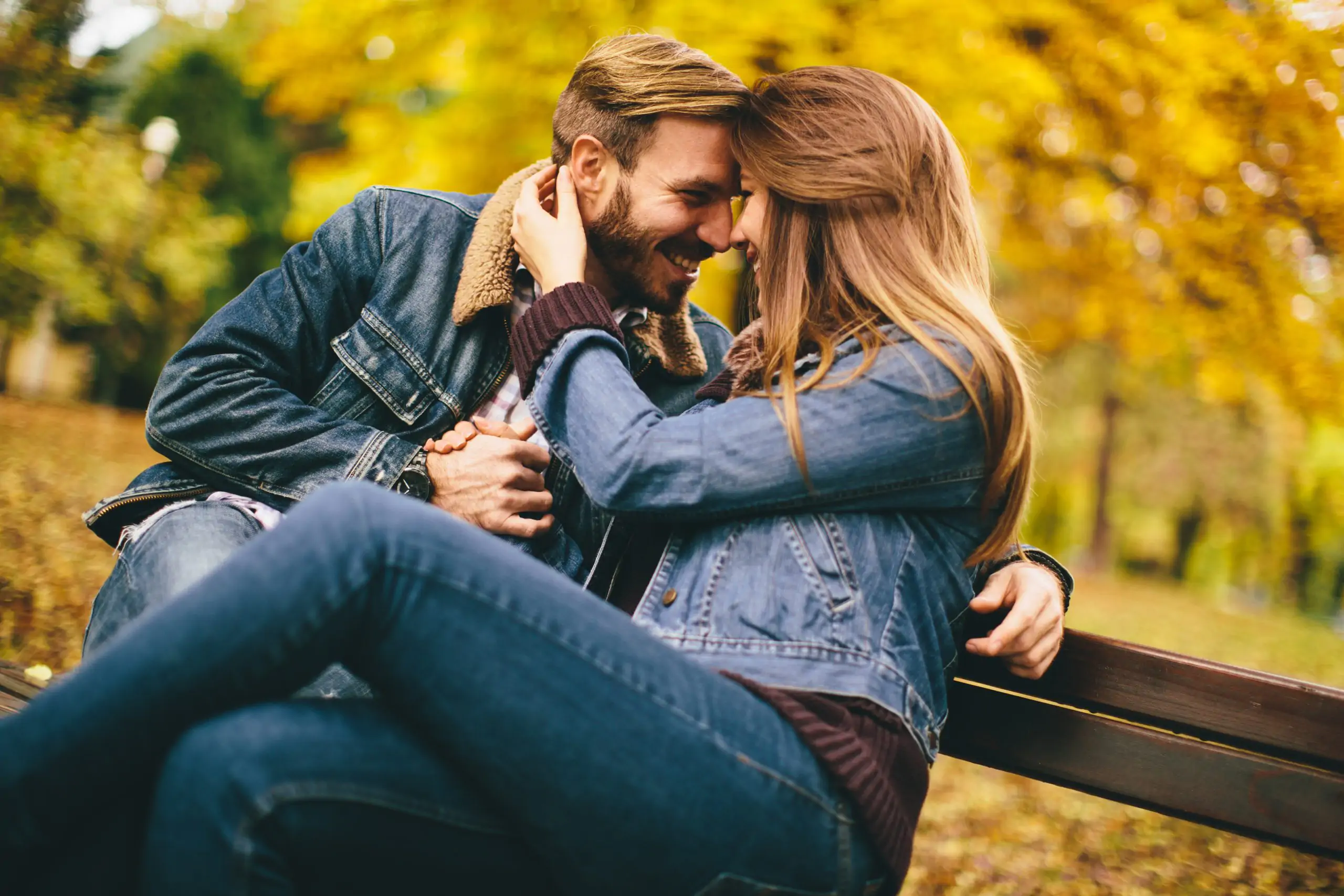 Loving and romantic couple on a bench in the autumn park